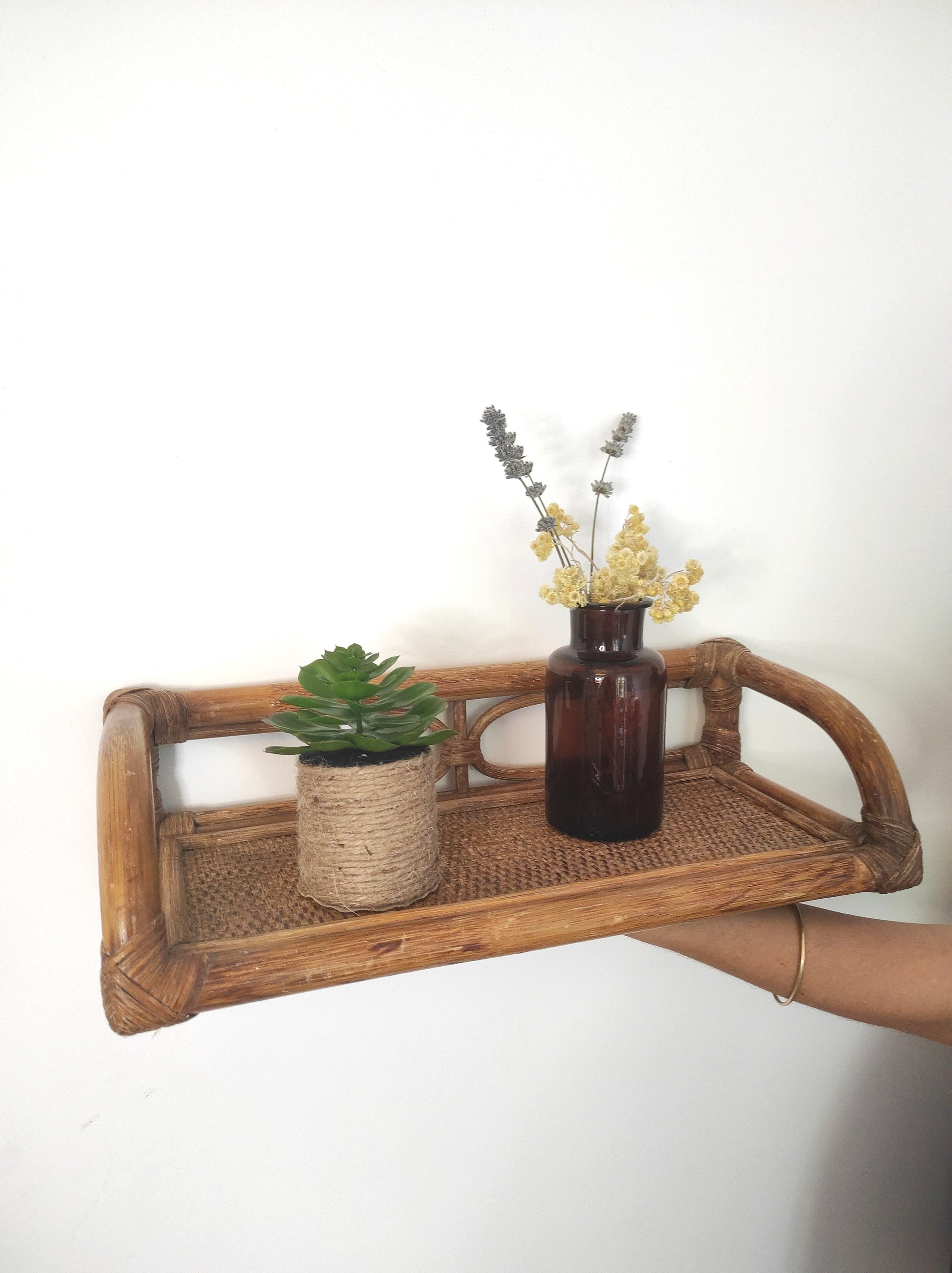 Jolie étagère murale en rotin vintage. Cette ancienne étagère murale en rotin trouvera sa place dans votre intérieur.   Son format est idéal pour s'adapter à toutes les pièces de la maison, et accueillir livres ou déco.  A noter : Dans son jus, le vernis est un peu passé à certains endroits mais reste en très bon état. 