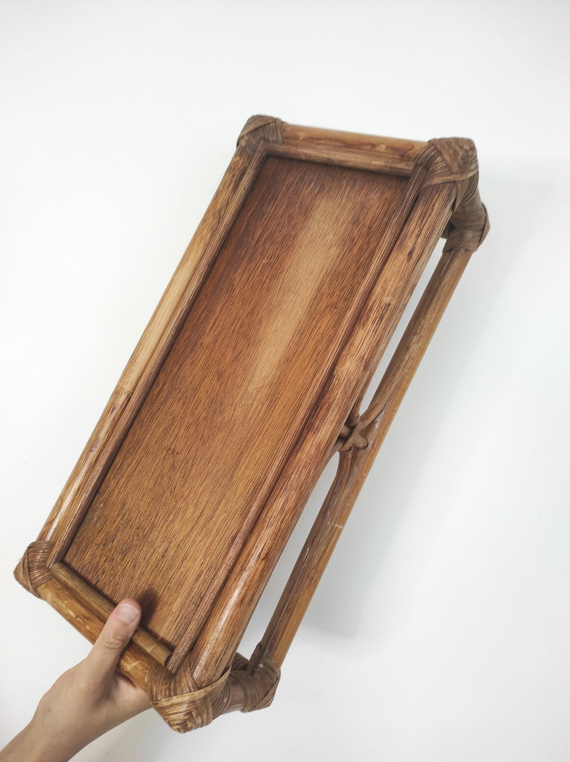 Cette ancienne étagère murale en rotin trouvera sa place dans votre intérieur.   Son format est idéal pour s'adapter à toutes les pièces de la maison, et accueillir livres ou déco.  A noter : Dans son jus, le vernis est un peu passé à certains endroits mais reste en très bon état. 