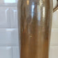 Ancienne bouteille en grès vernissé. Jolie bouteille ancienne en grès vernissé avec anse.  Sa forme élancée est très décorative et accueillera à merveille vos fleurs séchées.   En déco, elle fera aussi faire son effet en accumulation avec d’autres formats ou d'autres couleurs.  A noter : la bouteille ayant était faite artisanalement, elle porte quelques petits défauts qui n'enlèvent rien à son charme. Aucun éclat.