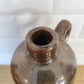 Ancienne bouteille en grès vernissé. Jolie bouteille ancienne en grès vernissé avec anse.  Sa forme élancée est très décorative et accueillera à merveille vos fleurs séchées.   En déco, elle fera aussi faire son effet en accumulation avec d’autres formats ou d'autres couleurs.  A noter : la bouteille ayant était faite artisanalement, elle porte quelques petits défauts qui n'enlèvent rien à son charme. Aucun éclat.