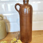 Ancienne bouteille en grès vernissé 23 cm. Jolie bouteille ancienne en grès vernissé avec anse.  Un peu plus petite que sa grande sœur elle reste tout de même très décorative et accueillera à merveille vos fleurs séchées.   En déco, elle fera aussi faire son effet en accumulation avec d’autres formats ou d'autres couleurs. Bouteille vintage